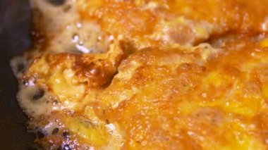 Et pirzolası tavada kızarır. Mutfakta bir domuz eti tabağı hazırlanır. Yağda, yağda ve yağda kızartılmış yiyecekler..