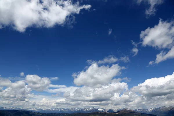 蓝蓝的天空和云彩的阿尔卑斯山顶峰 图库照片