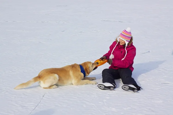 Девушка на коньках с собакой — стоковое фото