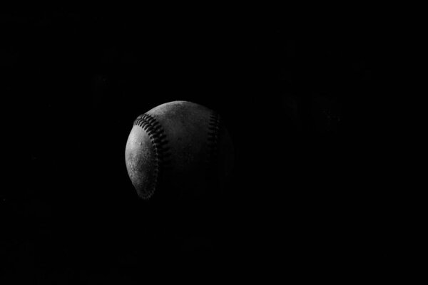 black and white baseball ball on a dark background