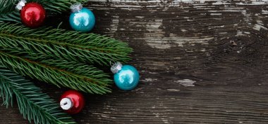 Noel arkaplanı köknar dalları ve tahta masanın üzerindeki toplar.. 