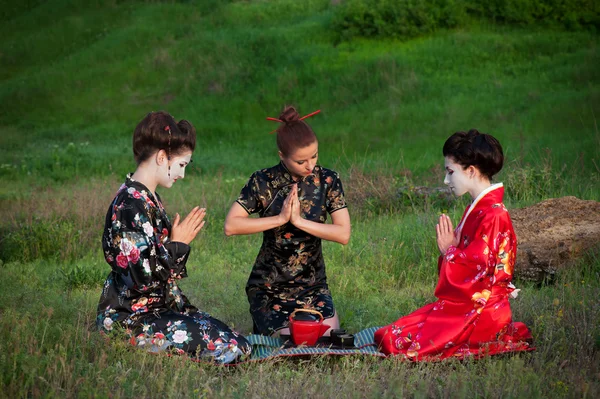 Tres mujeres bebiendo té en una manera asiática — Foto de Stock