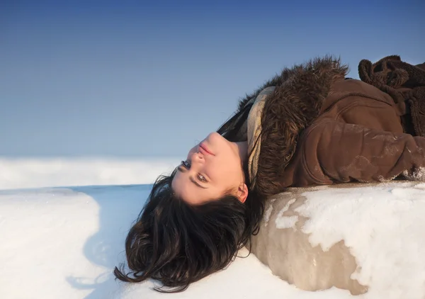 Menina deitada na neve — Fotografia de Stock