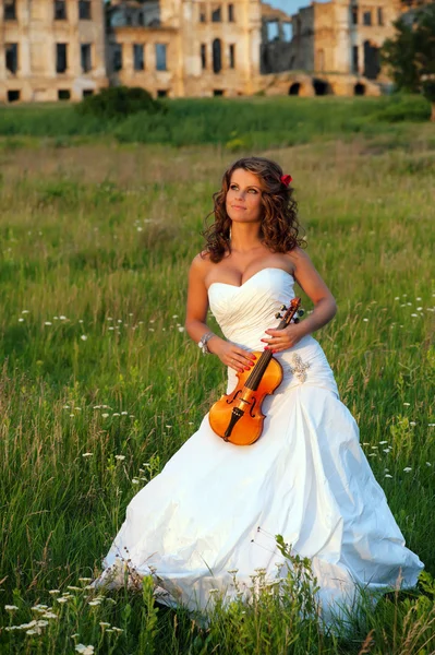 Smiling bride with violin in front of the ruins — Stock Photo, Image