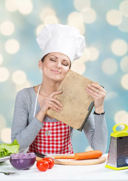 Woman in chef's hat with the old grandmother's cookbook — Stock Photo, Image