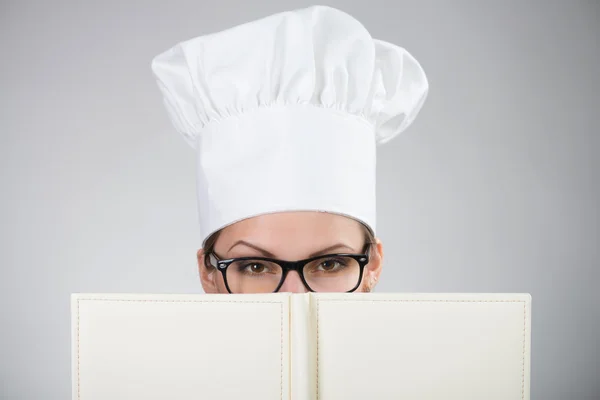 Frau mit Kochmütze blickt in die Kamera — Stockfoto