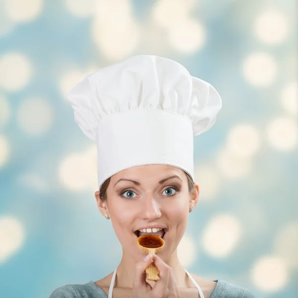 Mulher feliz no chapéu do chef degustação molho — Fotografia de Stock