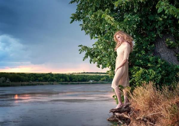 Blonde vrouw op de rivier bank — Stockfoto