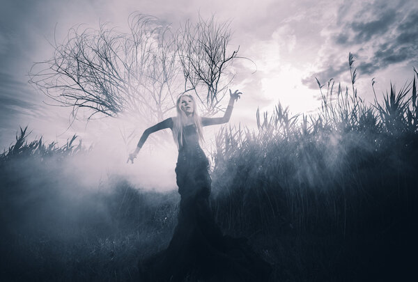 Demonic female figure in the fog, monochromatic shot