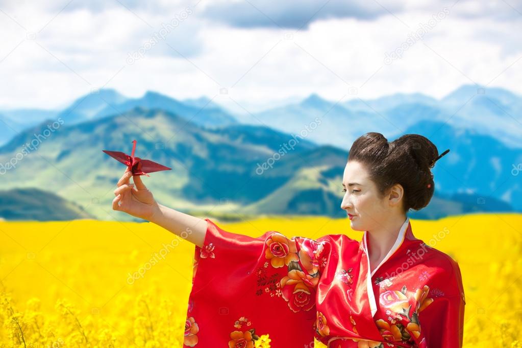 Geisha with an origami crane in the yellow flowering field