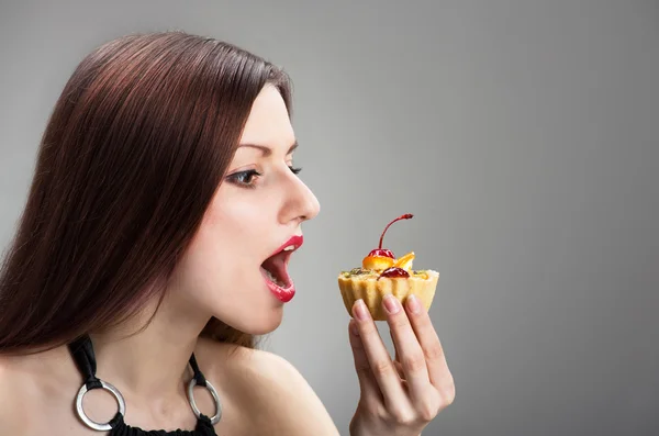 Girl nibbling the cake — Stock Photo, Image