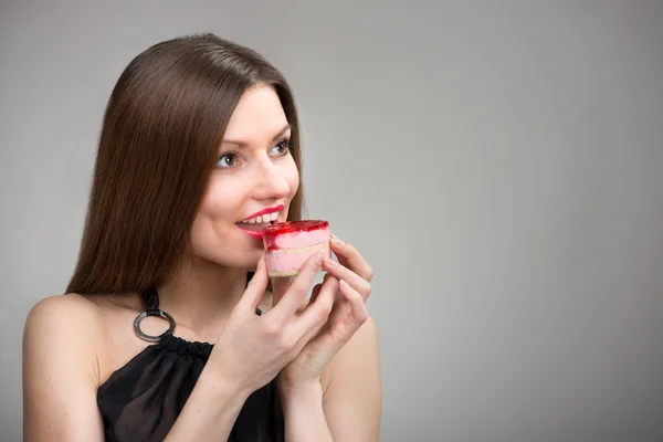 Smiling girl tasting the cake — Stock Photo, Image