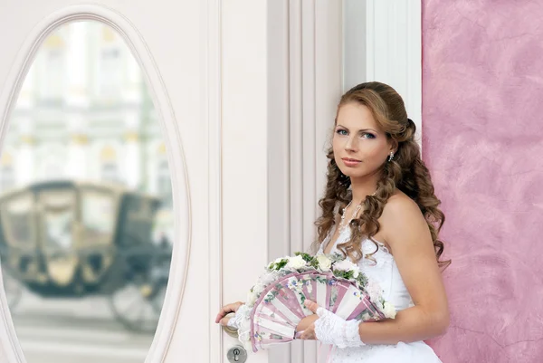 La novia con el abanico-ramo de boda ante el espejo — Foto de Stock