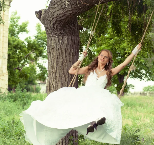 Smiling bride on the swings — Stock Photo, Image