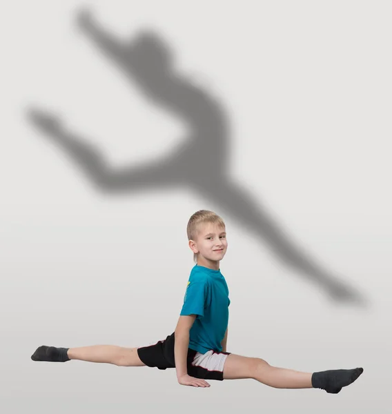 Jongen doen horizontale splitst met dancer's silhouet achter hem — Stockfoto