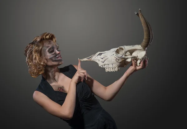 Жінка з черепом корови в руках, обличчям до обличчя — стокове фото