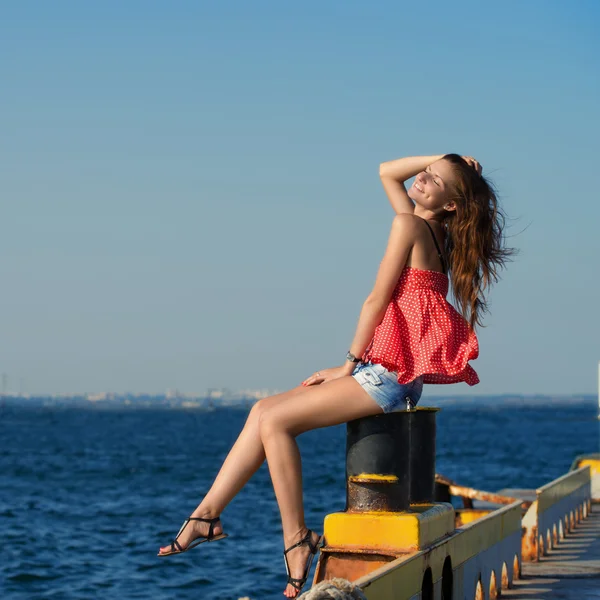 Hübsches Mädchen sitzt am alten Liegeplatz — Stockfoto