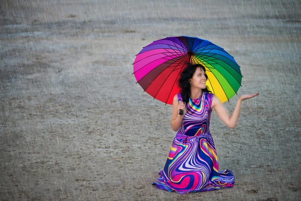 Donna con ombrello colorato sotto la pioggia — Foto Stock