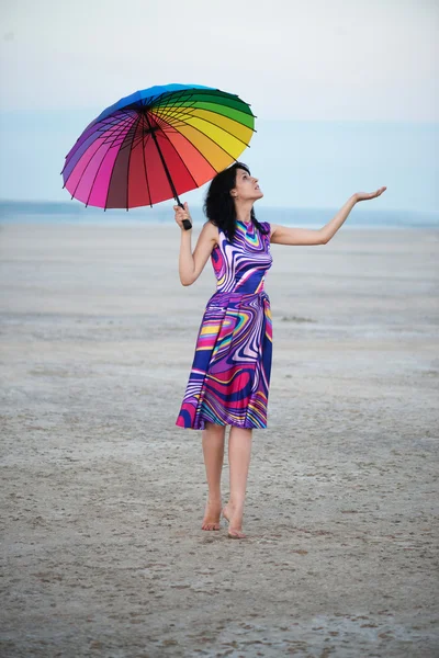Босоногая женщина с разноцветным зонтиком — стоковое фото