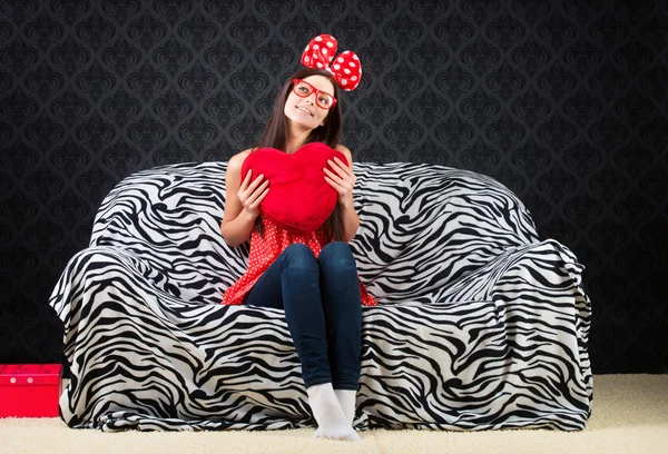 Portrait of a funny girl with a heart cushion — Stock Photo, Image