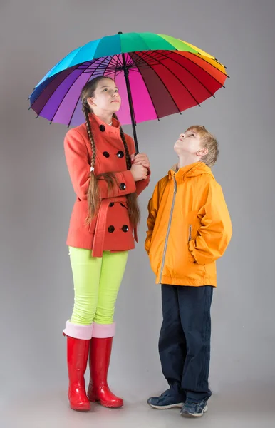 Niño y niña con un paraguas colorido — Foto de Stock