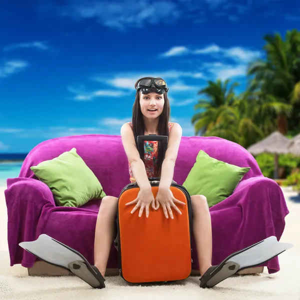 Смешная девушка со своим багажом, тропический пляж фон — стоковое фото