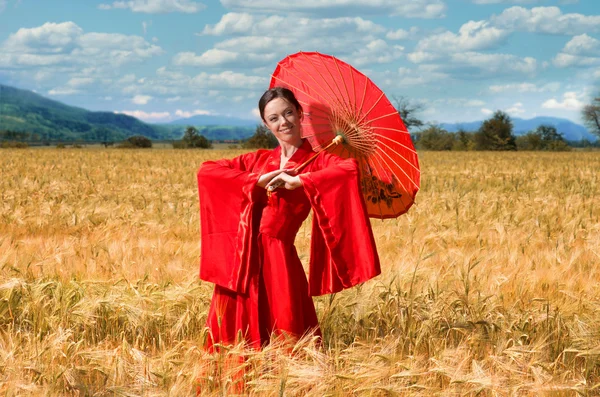 Mujer en kimono rojo en el campo de trigo — Foto de Stock
