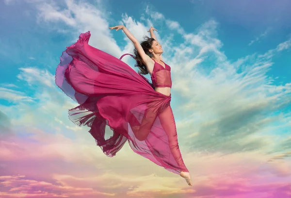 Girl jumping in the air at sunset — Stock Photo, Image