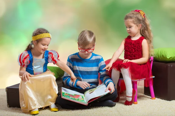Un garçon lit un livre aux petites filles — Photo