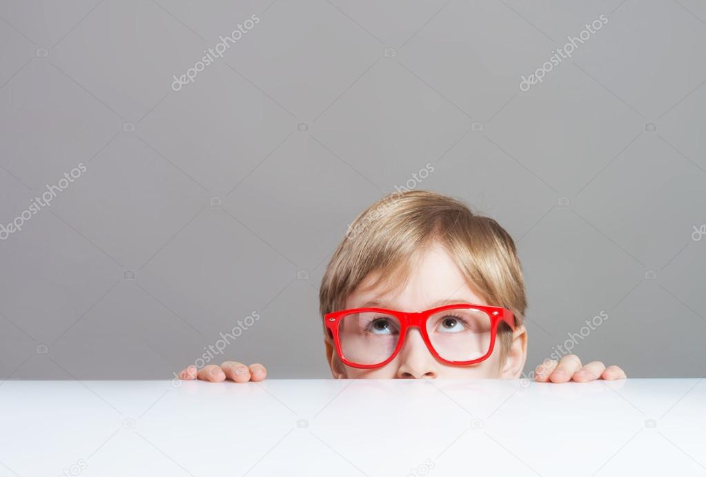 Boy looking up from behind the table