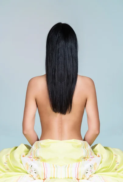 Mulher com cabelos longos sentada na cama — Fotografia de Stock