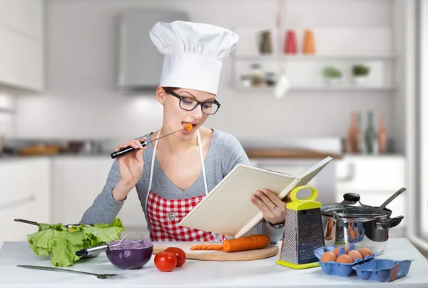 Vacker kvinna matlagning med kokbok — Stockfoto