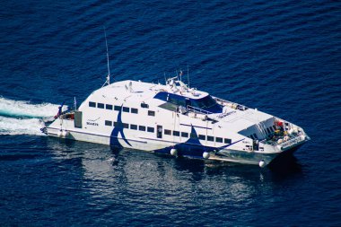 Santorini, Fira, Yunanistan - 08 Ekim 2021 Fira adası yakınlarındaki bir yolcu nakliye gemisinin havadan fotoğrafı, insanlar bu ulaşım aracını kullanarak adalar arasında seyahat ediyorlar.