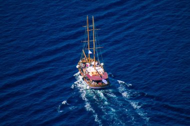 Santorini, Fira, Yunanistan - 08 Ekim 2021 Fira adası yakınlarındaki bir yolcu nakliye gemisinin havadan fotoğrafı, insanlar bu ulaşım aracını kullanarak adalar arasında seyahat ediyorlar.