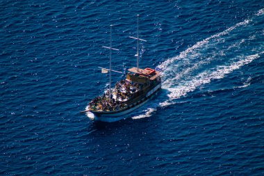 Santorini, Fira, Yunanistan - 08 Ekim 2021 Fira adası yakınlarındaki bir yolcu nakliye gemisinin havadan fotoğrafı, insanlar bu ulaşım aracını kullanarak adalar arasında seyahat ediyorlar.