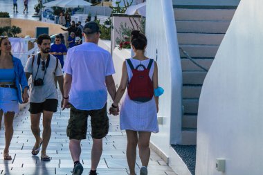 Santorini, Oia, Yunanistan - 18 Ekim 2021 Coronavirus salgını sırasında Yunanistan 'ı vuran ve sokakta maske takan ünlü tünemiş Oia kasabasını ziyaret eden turist topluluğu zorunlu değil