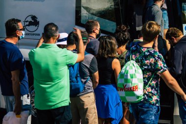 Santorini, Fira, Yunanistan - 20 Ekim 2021 Otobüs durağındaki turist kalabalığı, tüm otobüsler ayrılıp güzergahlarını, adanın kuzey ve güney uçlarını kapsayan 6 durak