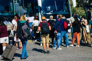 Santorini, Fira, Yunanistan - 20 Ekim 2021 Otobüs durağındaki turist kalabalığı, tüm otobüsler ayrılıp güzergahlarını, adanın kuzey ve güney uçlarını kapsayan 6 durak