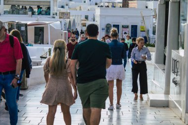 Santorini, Oia, Yunanistan - 18 Ekim 2021 Coronavirus salgını sırasında Yunanistan 'ı vuran ve sokakta maske takan ünlü tünemiş Oia kasabasını ziyaret eden turist topluluğu zorunlu değil