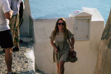 Santorini, Oia, Yunanistan - 18 Ekim 2021 Coronavirus salgını sırasında Yunanistan 'ı vuran ve sokakta maske takan ünlü tünemiş Oia kasabasını ziyaret eden turist topluluğu zorunlu değil