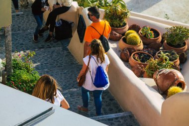Santorini, Oia, Yunanistan - 18 Ekim 2021 Coronavirus salgını sırasında Yunanistan 'ı vuran ve sokakta maske takan ünlü tünemiş Oia kasabasını ziyaret eden turist topluluğu zorunlu değil