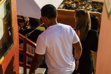 Santorini, Oia, Yunanistan - 18 Ekim 2021 Coronavirus salgını sırasında Yunanistan 'ı vuran ve sokakta maske takan ünlü tünemiş Oia kasabasını ziyaret eden turist topluluğu zorunlu değil