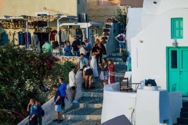 Santorini, Oia, Yunanistan - 18 Ekim 2021 Coronavirus salgını sırasında Yunanistan 'ı vuran ve sokakta maske takan ünlü tünemiş Oia kasabasını ziyaret eden turist topluluğu zorunlu değil