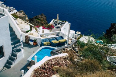 Santorini, Oia, Yunanistan - 24 Ekim 2021 Oia kentinin manzarası, bu adanın tipik küçük geleneksel beyaz evleri antik aktif volkanın yanında yer almaktadır.