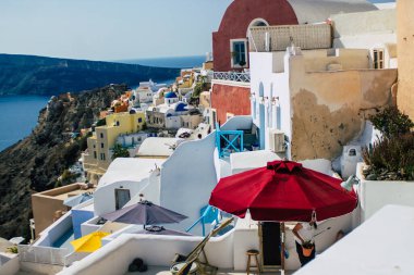 Santorini, Oia, Yunanistan - 24 Ekim 2021 Oia kentinin manzarası, bu adanın tipik küçük geleneksel beyaz evleri antik aktif volkanın yanında yer almaktadır.