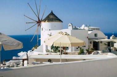 Santorini, Oia, Yunanistan - 24 Ekim 2021 Oia kentinin manzarası, bu adanın tipik küçük geleneksel beyaz evleri antik aktif volkanın yanında yer almaktadır.
