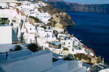 Santorini, Oia, Yunanistan - 24 Ekim 2021 Oia kentinin manzarası, bu adanın tipik küçük geleneksel beyaz evleri antik aktif volkanın yanında yer almaktadır.