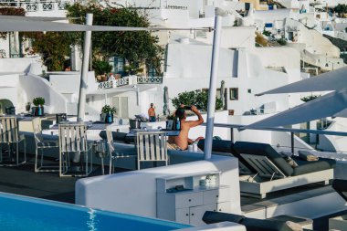 Santorini, Oia, Yunanistan - 24 Ekim 2021 Coronavirus salgını sırasında Yunanistan 'ı vuran ve sokakta maske takan ünlü tünemiş Oia kasabasını ziyaret eden turist topluluğu zorunlu değil