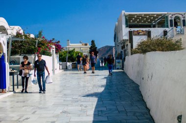 Santorini, Oia, Yunanistan - 24 Ekim 2021 Coronavirus salgını sırasında Yunanistan 'ı vuran ve sokakta maske takan ünlü tünemiş Oia kasabasını ziyaret eden turist topluluğu zorunlu değil