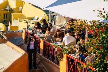 Santorini, Oia, Yunanistan - 24 Ekim 2021 Coronavirus salgını sırasında Yunanistan 'ı vuran ve sokakta maske takan ünlü tünemiş Oia kasabasını ziyaret eden turist topluluğu zorunlu değil